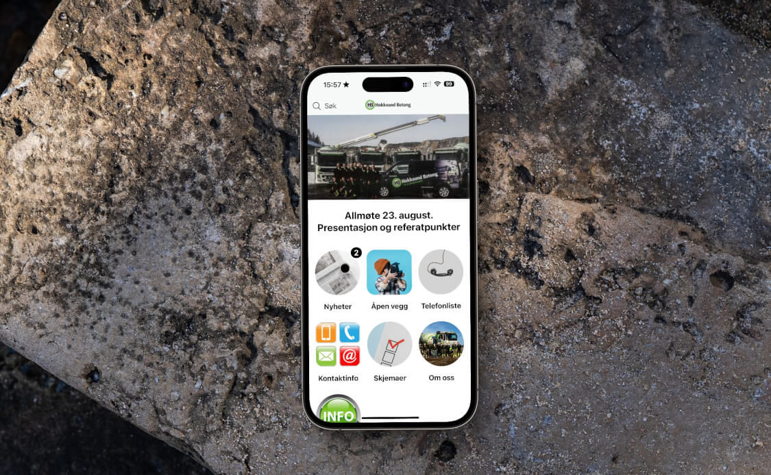 En iPhone med appen til Hokksund Betong ligger på en betongblokk. Foto.